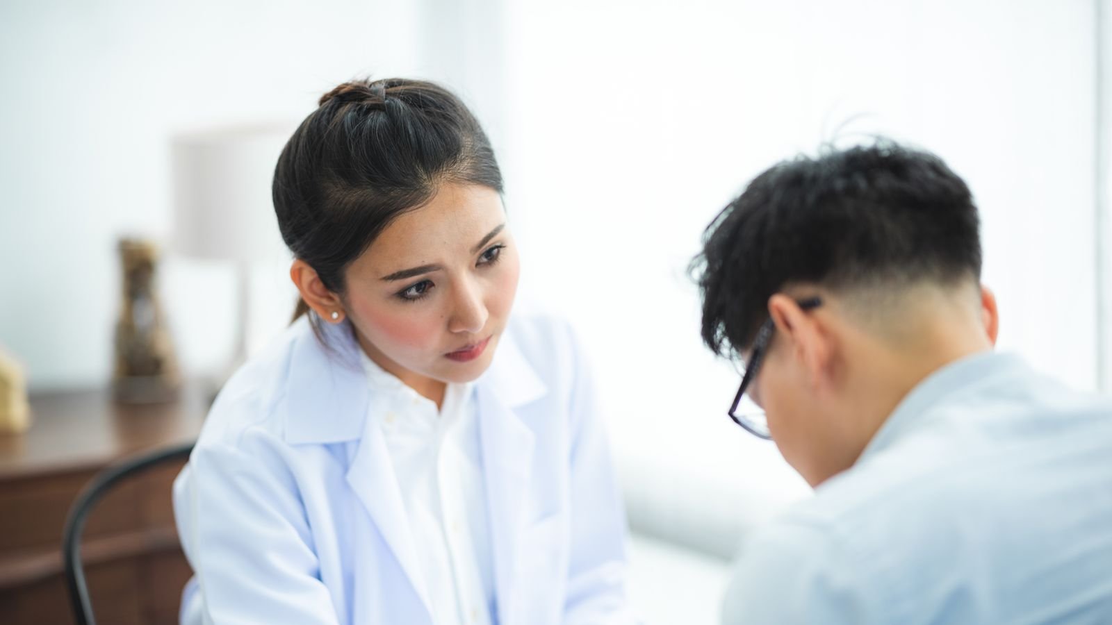 Médecin et patient discutant d'un dossier lors d'une consultation